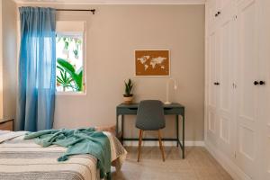 a bedroom with a desk and a bed and a window at Casa Galicia in El Médano