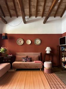 een woonkamer met een bank en borden aan de muur bij Villa Il Pensierino in Manciano