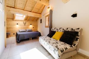 a bedroom with a bed and a couch in a room at Meribel le chalet d'eugénie in Les Allues