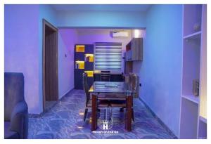a dining room with a table and a purple wall at Luxury 3bedroom in Serene Estate Kubwa FCT in Kubwa