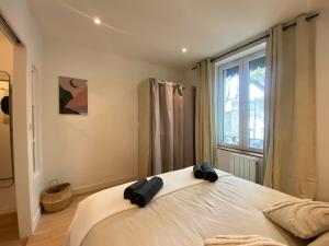 een slaapkamer met een groot wit bed met een raam bij Le Suchet in Lyon