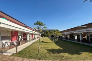 une cour avec des chaises et des arbres dans un bâtiment dans l'établissement U-Thong Garden Resort, à Ban Na Kaum Tai