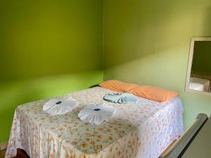 a bedroom with a bed with four pillows on it at Pousada Vila da Praia in Santarém