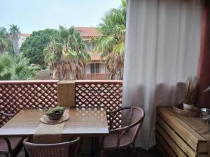 a balcony with a table and chairs and a window at T3 duplex malibu village pass piscine en supplément 2 a 8 personnes in Canet-en-Roussillon
