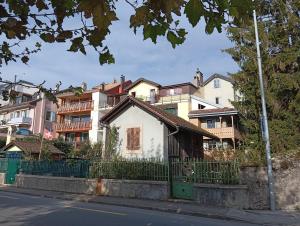 a small white house in front of a building at Studio Le rêve de Rive in Nyon