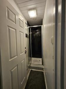 a hallway with a door and a shower in it at Inspire Home Stylish Stay D in Cardiff