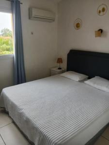 a bedroom with a white bed with a window at T3 duplex malibu village pass piscine en supplément 2 a 8 personnes in Canet-en-Roussillon +18 photos