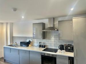 a kitchen with a sink and a counter top at Two Bedroom Flat by Brookland Stays Serviced Accommodation Short Lets Leeds with Free WiFi in Leeds