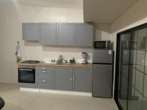 a kitchen with white cabinets and a stainless steel refrigerator at Curacasitas in Willemstad