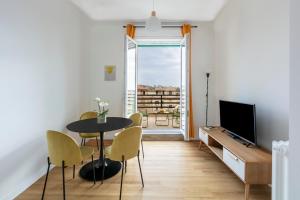 a living room with a table and chairs and a television at Casa Vespi by Hili in Rome