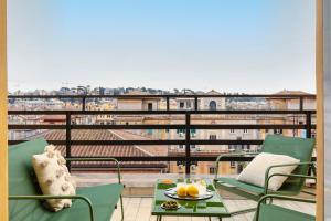 a balcony with chairs and a table with fruit on it at Casa Vespi by Hili in Rome