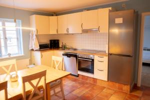 a kitchen with a table and a stainless steel refrigerator at Ferienwohnung Techin am Schaalsee in Techin