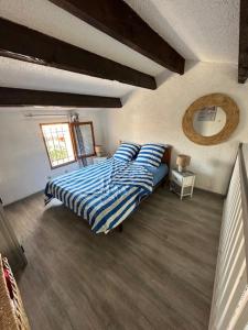een slaapkamer met een bed met blauwe lakens en een spiegel bij VILLA DU PIN in Gruissan +42 foto's