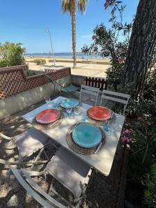 een tafel met borden en glazen erop bij VILLA DU PIN in Gruissan