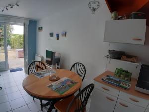 - une cuisine avec une table et des chaises en bois dans l'établissement Opal'In, au Crotoy