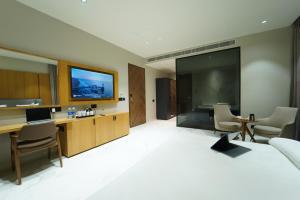 a hotel room with a bed and a desk and a tv at Hotel Millennium in Hisār