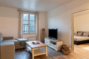 a small living room with a bed and a television at Appartement au cœur de Senlis in Senlis