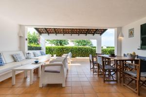 a living room with a couch and a table and chairs at Villa Esther vistas al mar Menorca in Cap d'en Font