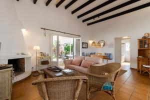 a living room with a couch and chairs and a fireplace at Villa Esther vistas al mar Menorca in Cap d'en Font