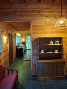 a living room with wooden walls and a kitchen at Nidos del Chucao in Pucón