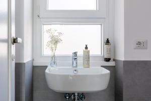 a white sink in a bathroom with a window at Casa Vespi by Hili in Rome +22 photos