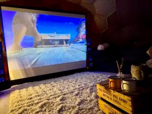 a large screen tv sitting on top of a bed at Deerstone Glamping-Boulsworth Hill Dome Hot tub in Earby