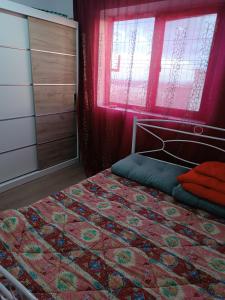 a bedroom with a bed with a red curtain and a window at Casa Iriss in Calafat