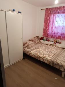 a bedroom with a bed and a pink curtain at Casa Iriss in Calafat