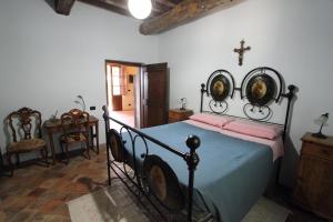 sypialnia z łóżkiem z krzyżem na ścianie w obiekcie il Cottage della Ginestra w mieście Morruzze