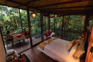 a bedroom with a large bed in a room with windows at Amazon Puyu Glamping in Tarqui