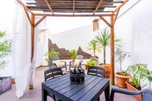 a patio with a table and chairs and potted plants at epicenter CITY in Ponta Delgada