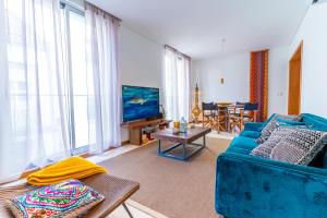 a living room with a blue couch and a tv at epicenter CITY in Ponta Delgada
