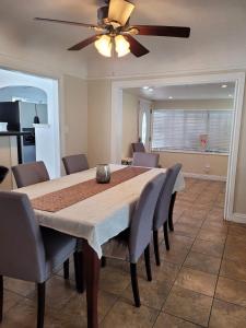 Una mesa de comedor con sillas y un ventilador de techo. en Cozy Spacious, free parking, near it all, en South Gate