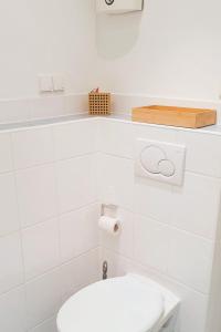 a bathroom with a toilet and a toilet paper dispenser at Haus Hanne Sylt Wohnung Obergeschoss in Sylt