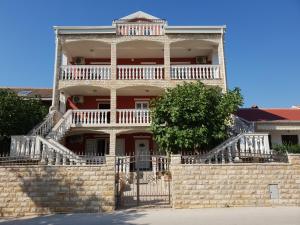 an old brick building with a balcony on top at Apartmani 'Bodulo' in Povljana
