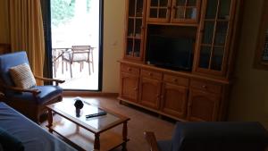 a living room with a couch and a tv and a table at Apartamento Atlanterra Playa in Zahara de los Atunes