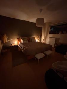 a bedroom with a large bed with white stools at La maison noire au coin in Bruges +17 photos