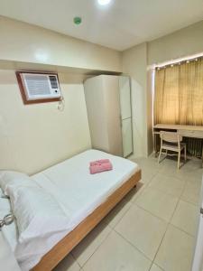 a bedroom with a bed and a bathroom with a sink at Avida Towers 2 Bedroom by PHI Rentals in Iloilo City +13 photos