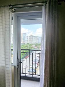 a door to a balcony with a view of a parking lot at Avida Towers 2 Bedroom by PHI Rentals in Iloilo City