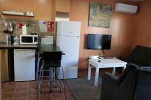 a kitchen with a refrigerator and a table with a microwave at DADA CAÑOS in Los Caños de Meca