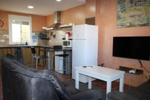 a living room with a white refrigerator and a table at DADA CAÑOS in Los Caños de Meca