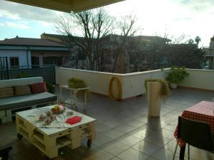 a patio with a table and a couch on a balcony at Cappuccini apartments superior in Oristano