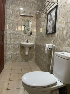 un baño con inodoro y lavabo en Emmalanta Safaris House, en Arusha 2 fotos más