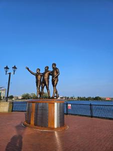 a statue of three children on the side of the water at Inspire Home Stylish Stay E in Cardiff