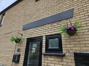 a brick building with two potted plants on it at Cosy Double Room Near Cardiff Bay Waterfront in Cardiff