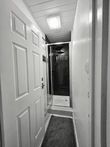 a bathroom with a door and a walk in shower at Inspire Home Stylish Stay E in Cardiff +3 photos