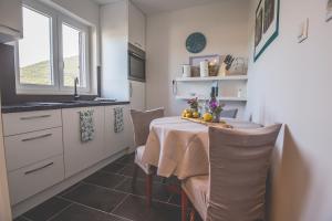 a kitchen with a table with chairs and a window at Violet Seaview Apartment in Vis