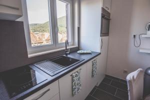 a small kitchen with a sink and a window at Violet Seaview Apartment in Vis