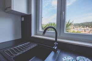 a kitchen counter with a sink and a window at Violet Seaview Apartment in Vis