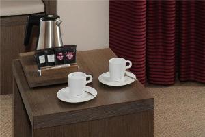 two cups and saucers on a wooden coffee table at Mercure Bayeux Omaha Beach in Port-en-Bessin-Huppain